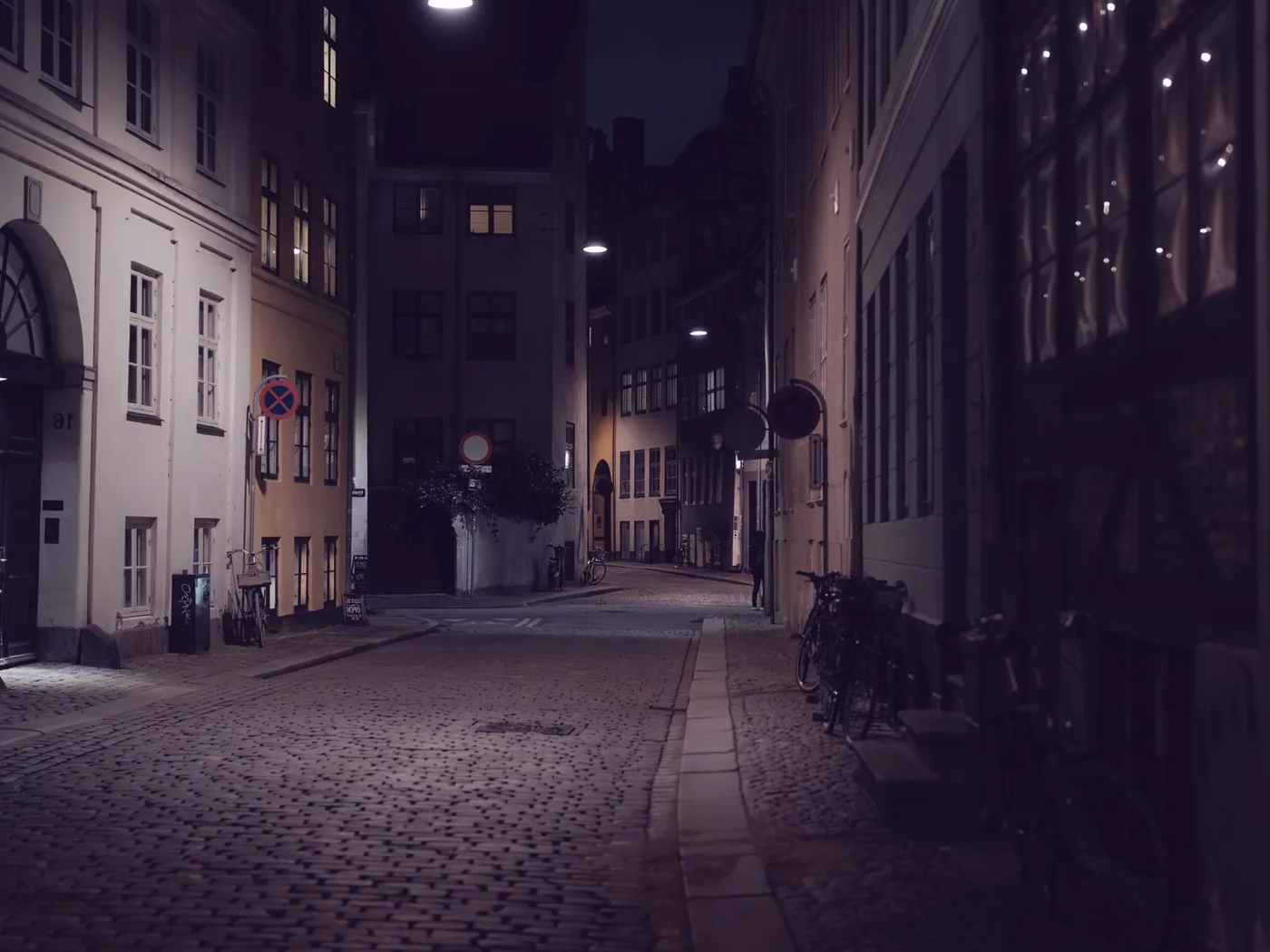 The street outside, cobbles and lamplight after dark